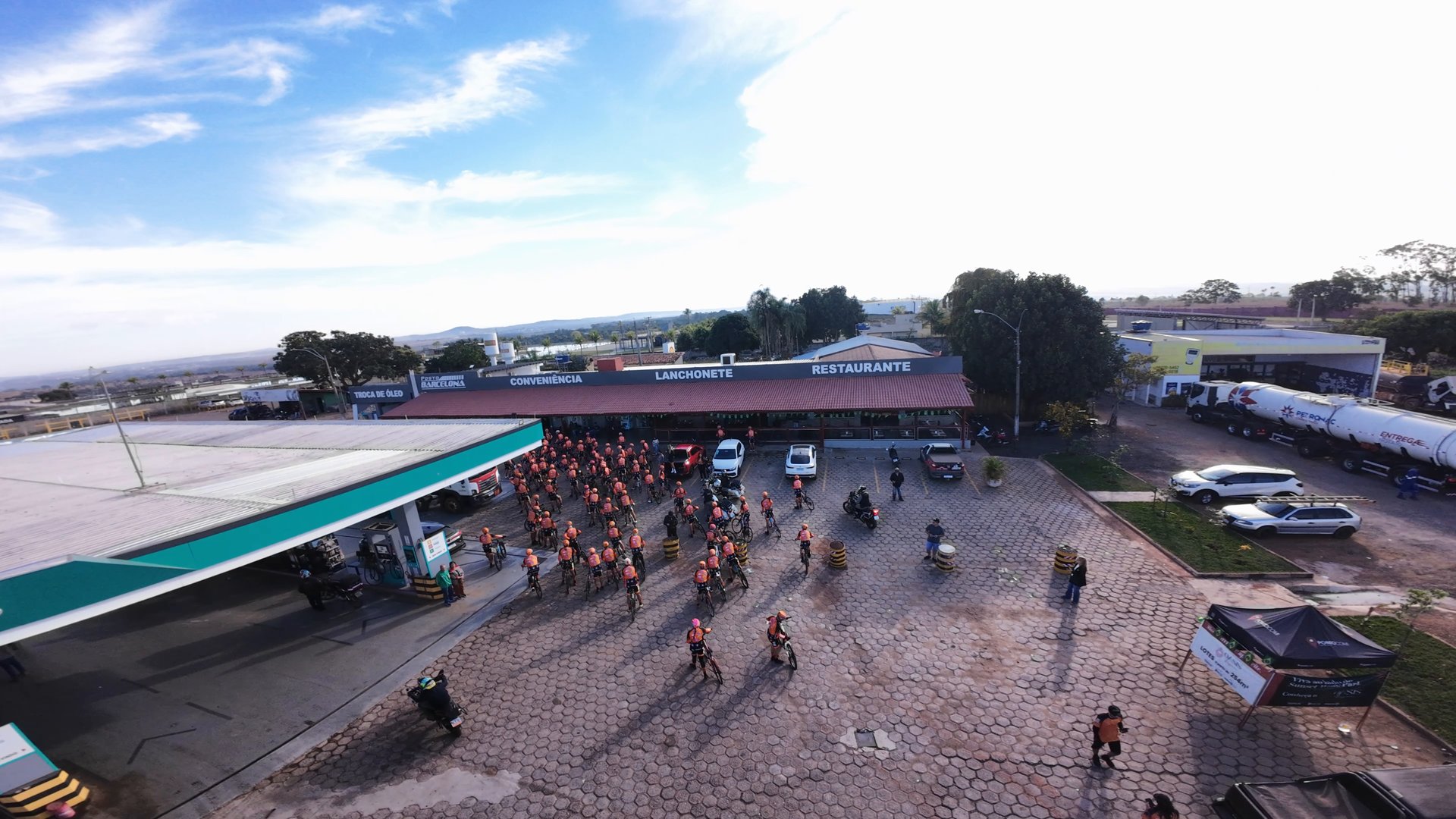Grupo de ciclistas no pátio do posto